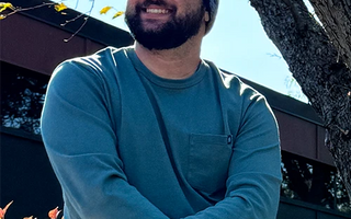 man sitting in tree wearing 4T2D beanie and tee